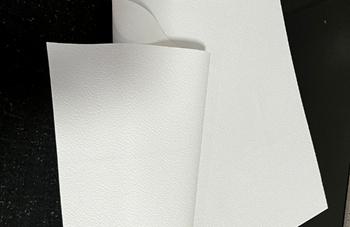 A white paper folded on a black surface

Description automatically generated