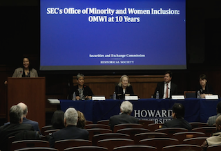 A panel featuring, from left to right: Haima Marlier (standing at podium), Pamela Gibbs, Mary Schapiro, Jay Clayton, Mary 